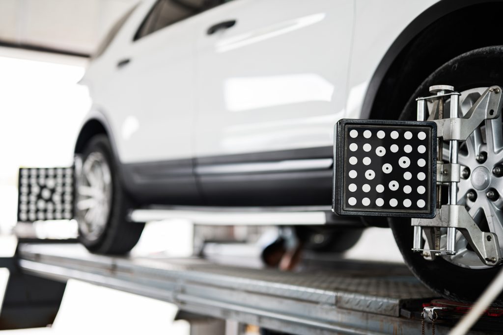 modern car wheel undergoing alignment on lift in garage